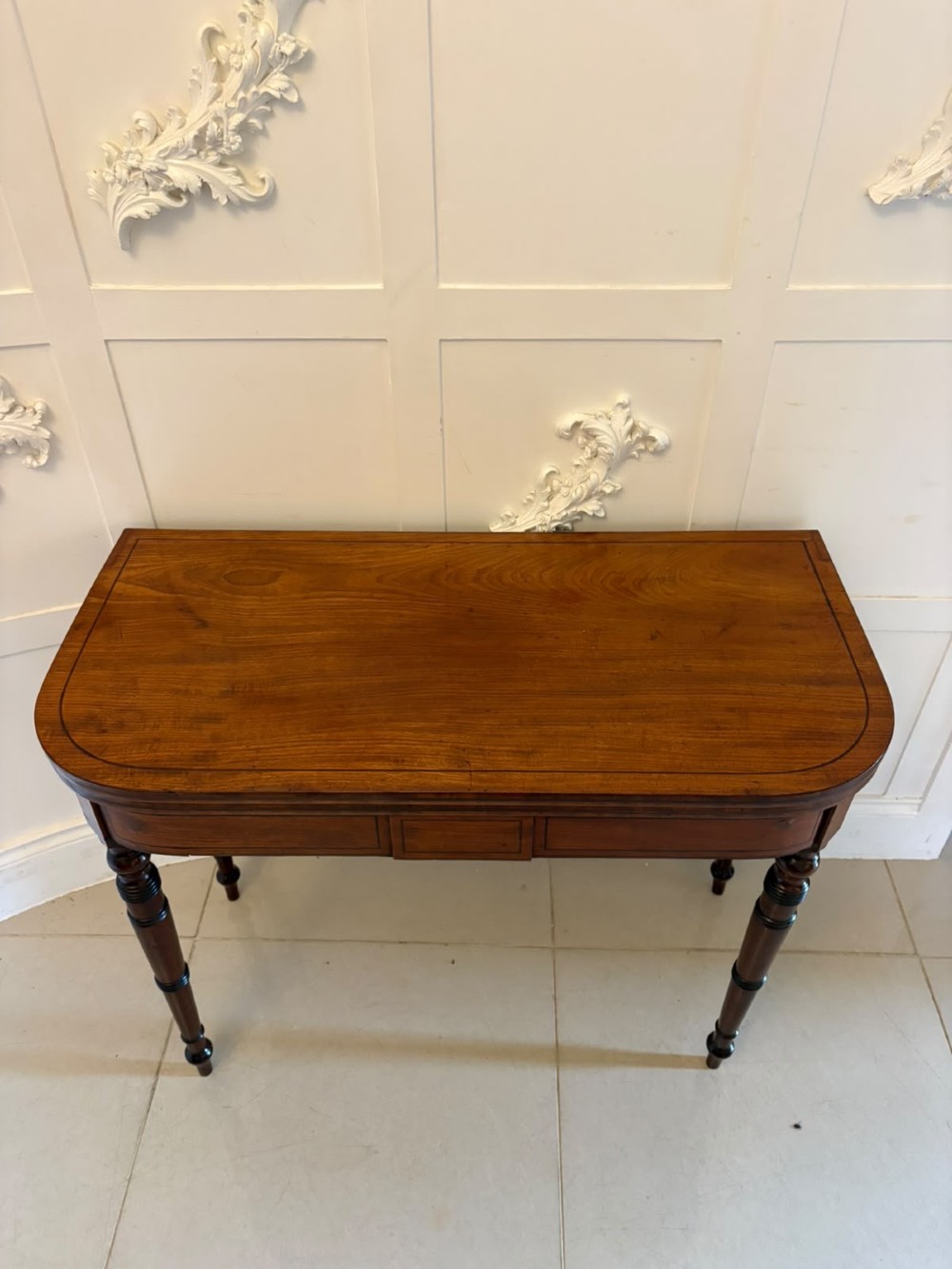 An antique Georgian mahogany fold-over card table featuring turned legs and subtle inlay stringing. View VI