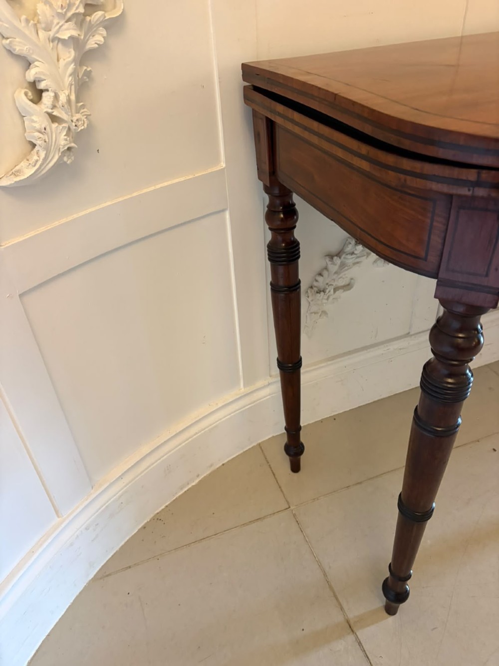 An antique Georgian mahogany fold-over card table featuring turned legs and subtle inlay stringing. View IX