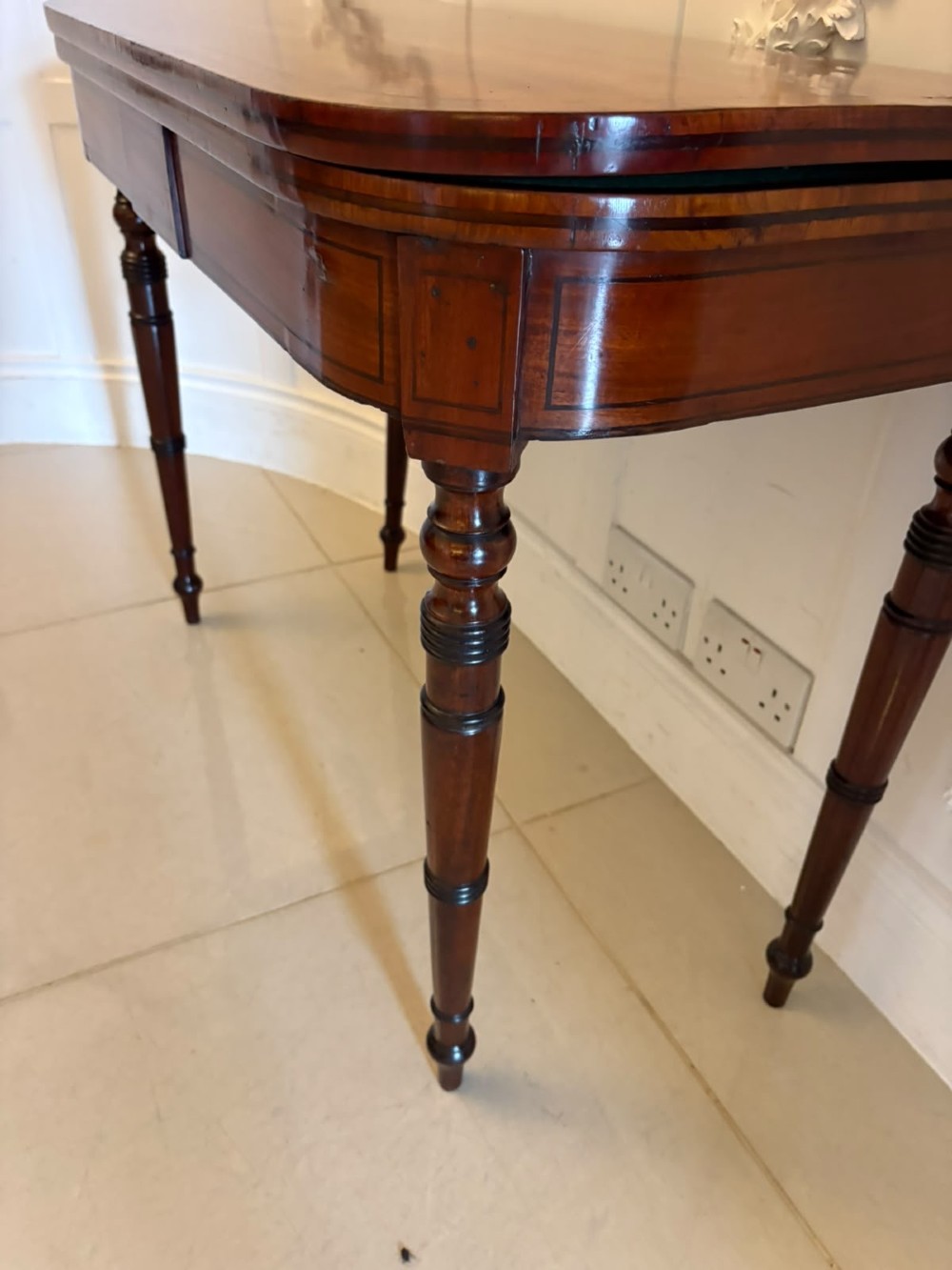 An antique Georgian mahogany fold-over card table featuring turned legs and subtle inlay stringing. View XI