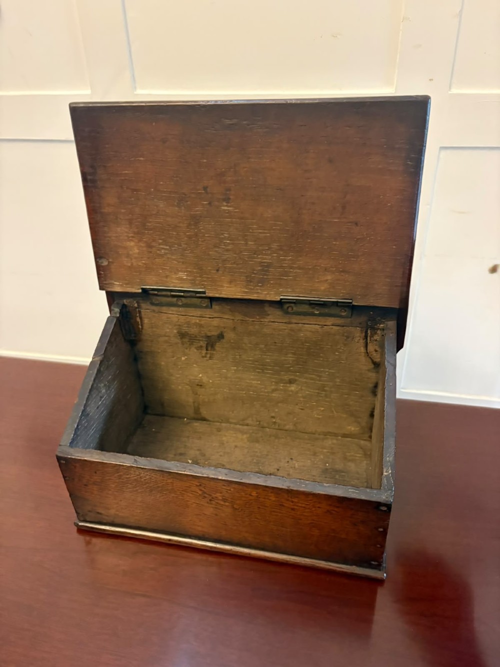 A dark oak Georgian wall-hanging candle box featuring a sloped hinged lid and a shaped backboard with two mounting holes. View V