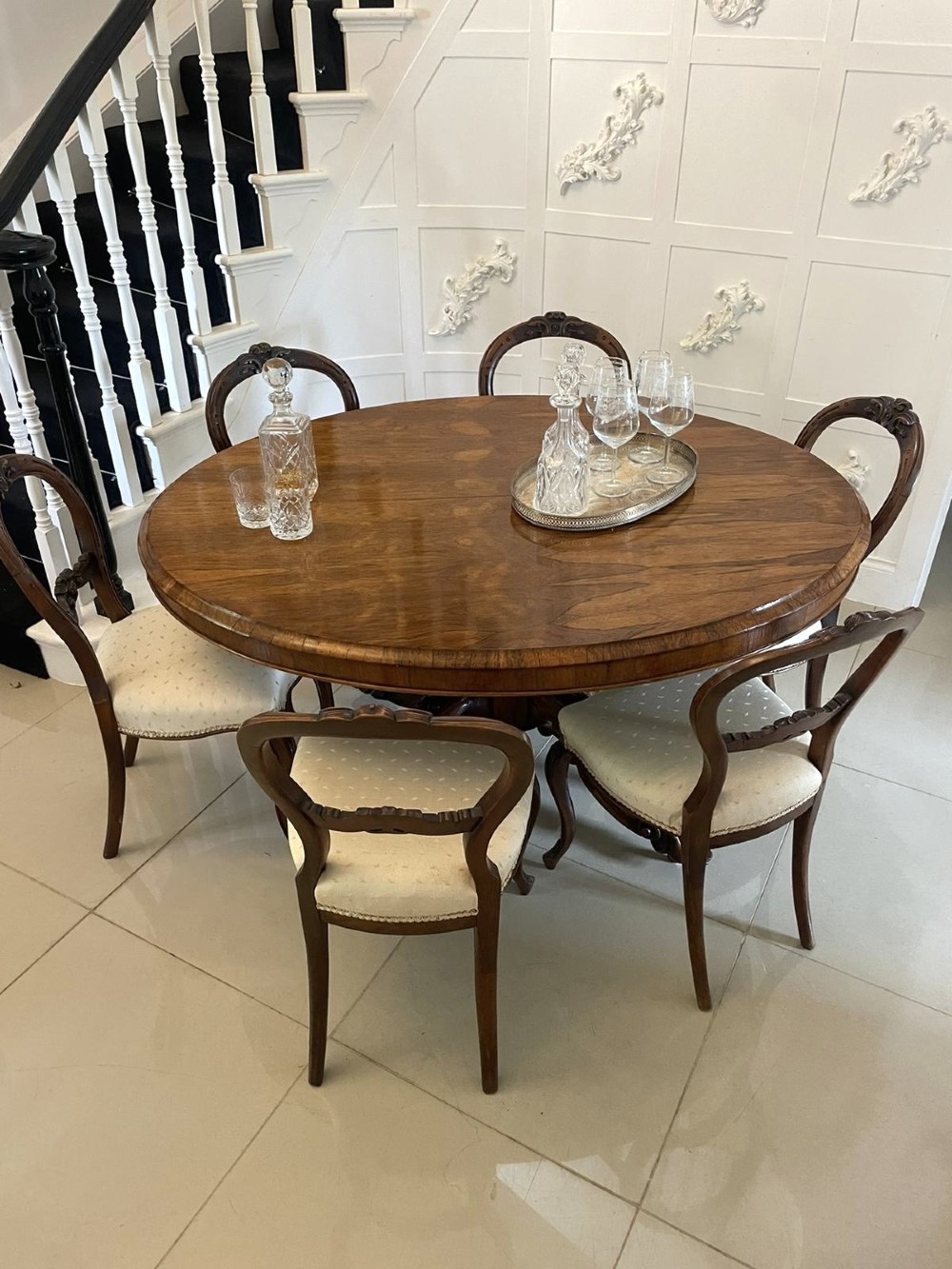 An antique Victorian rosewood tilt-top centre table shown with the circular top tilted vertically on a carved pedestal base. View II