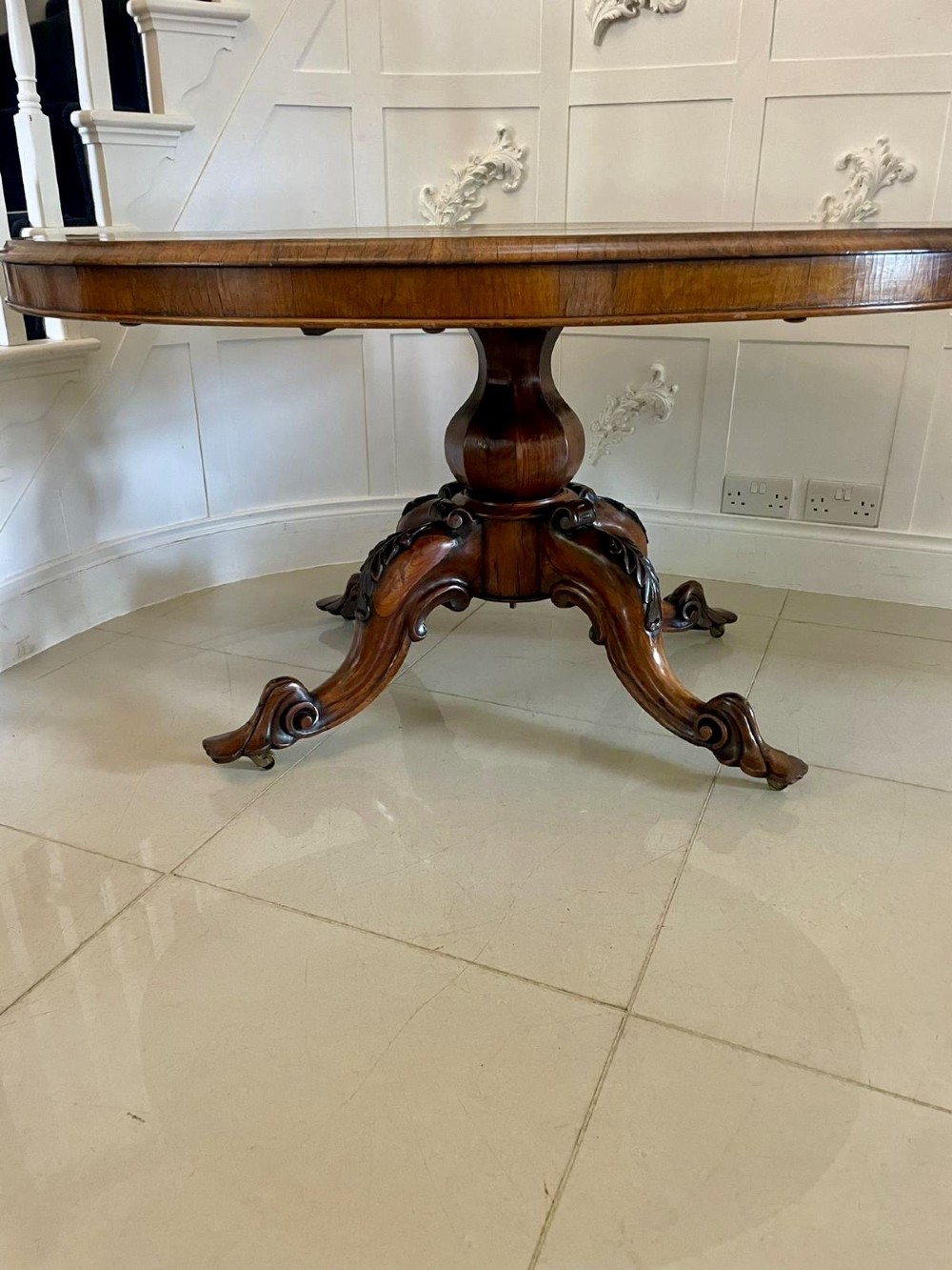 An antique Victorian rosewood tilt-top centre table shown with the circular top tilted vertically on a carved pedestal base. View IV