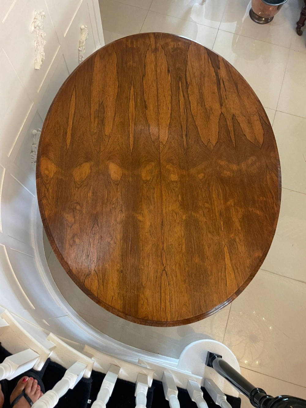 An antique Victorian rosewood tilt-top centre table shown with the circular top tilted vertically on a carved pedestal base. View VI