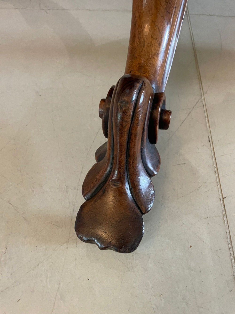 An antique Victorian rosewood tilt-top centre table shown with the circular top tilted vertically on a carved pedestal base. View X