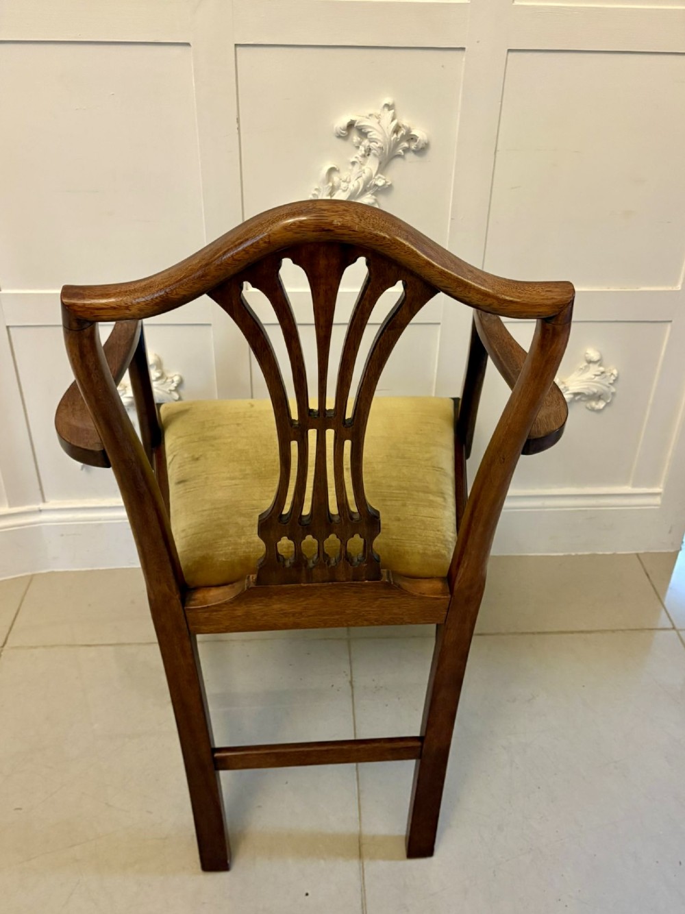 A set of twelve mahogany Hepplewhite style dining chairs featuring shield backs with carved splats and gold velvet drop-in seats. View V