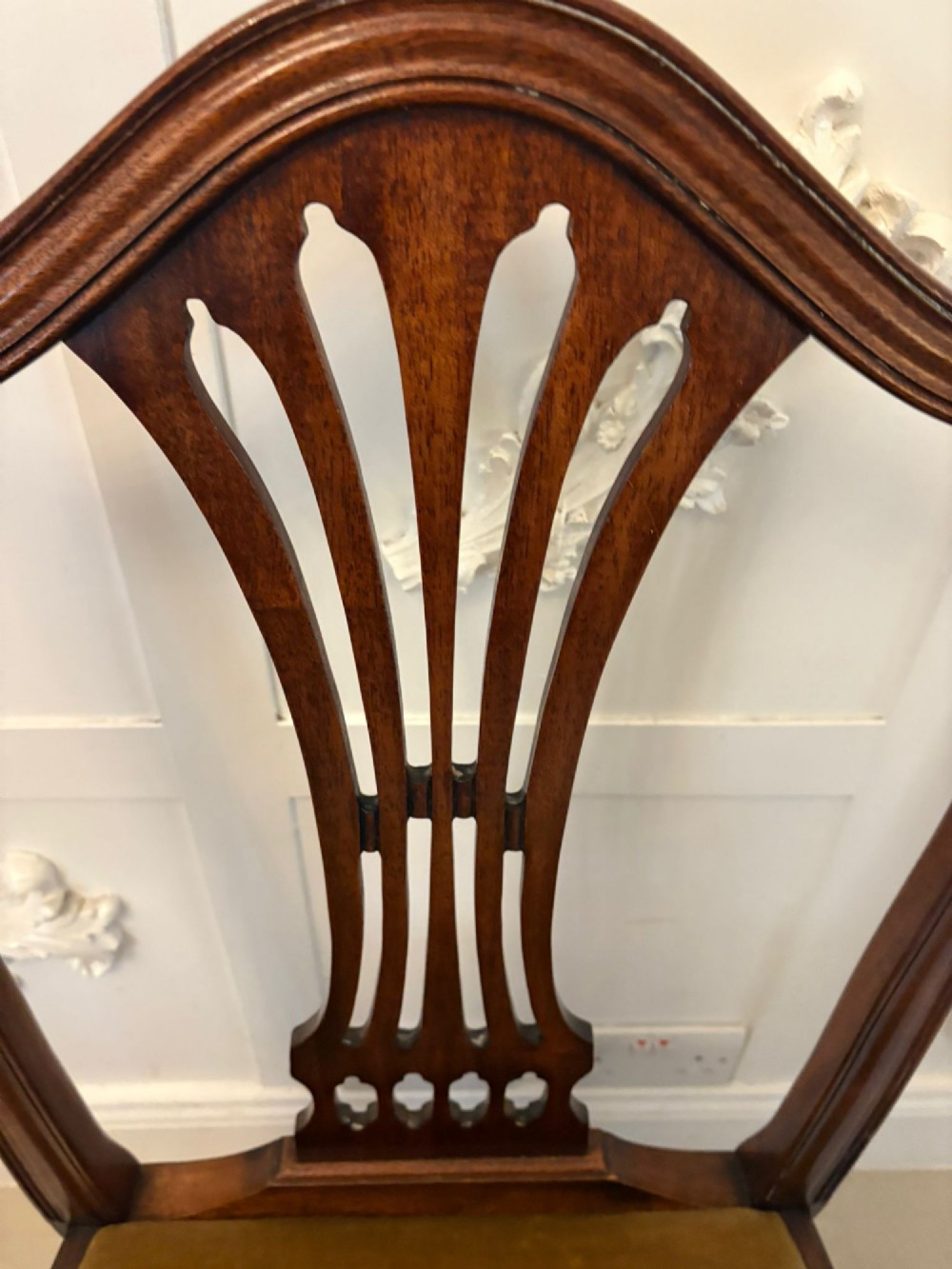A set of twelve mahogany Hepplewhite style dining chairs featuring shield backs with carved splats and gold velvet drop-in seats. View XI