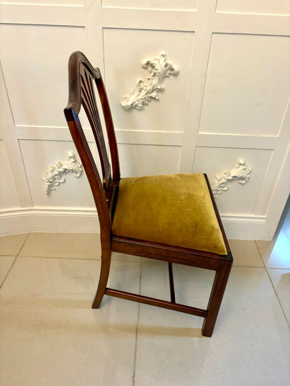 A set of twelve mahogany Hepplewhite style dining chairs featuring shield backs with carved splats and gold velvet drop-in seats. View XII