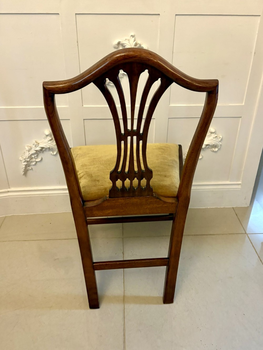 A set of twelve mahogany Hepplewhite style dining chairs featuring shield backs with carved splats and gold velvet drop-in seats. View XIII