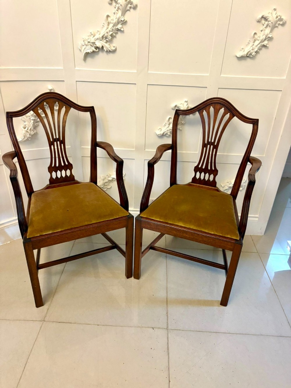 A set of twelve mahogany Hepplewhite style dining chairs featuring shield backs with carved splats and gold velvet drop-in seats. View XV