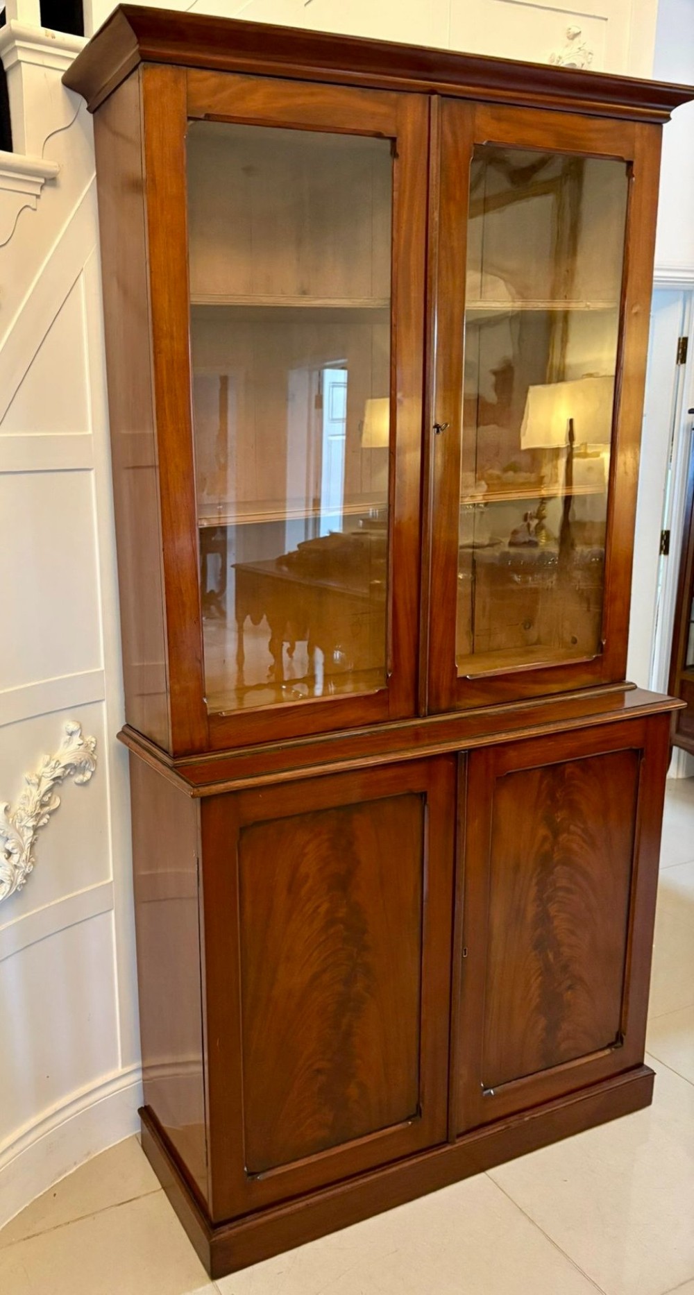 An antique Victorian mahogany bookcase featuring two upper glass-glazed doors and two lower flame mahogany panelled cupboard doors. View XI