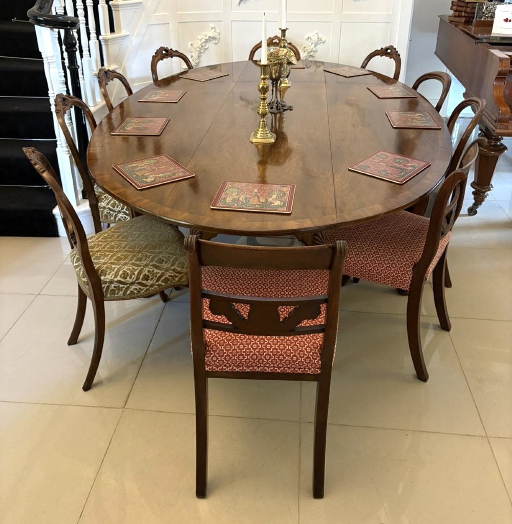 A large oval figured walnut wake dining table featuring drop leaves and cabriole legs ending in pad feet. View II