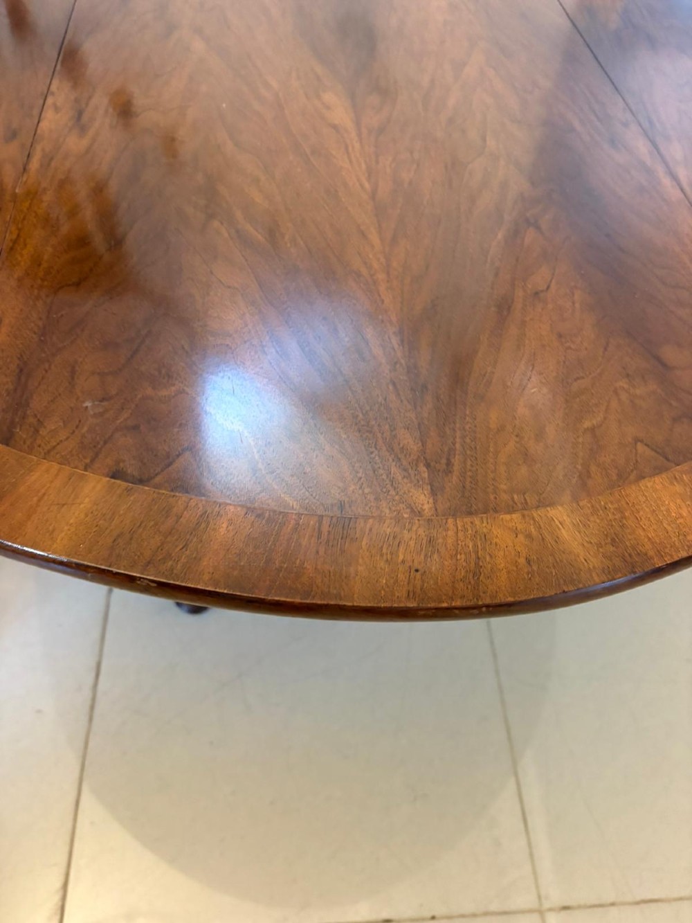 A large oval figured walnut wake dining table featuring drop leaves and cabriole legs ending in pad feet. View VI