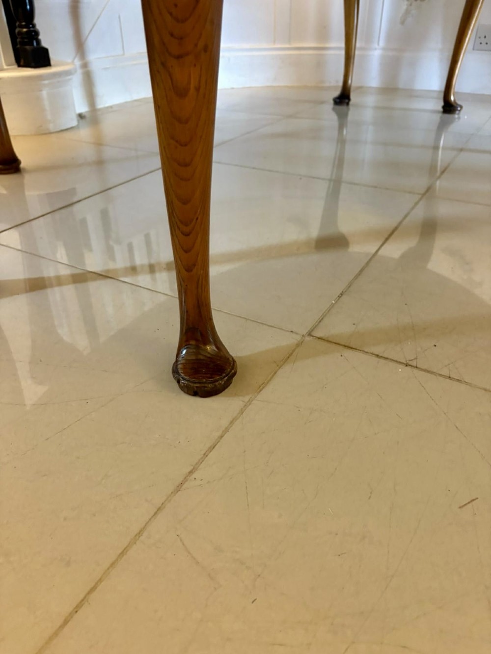 A large oval figured walnut wake dining table featuring drop leaves and cabriole legs ending in pad feet. View VII
