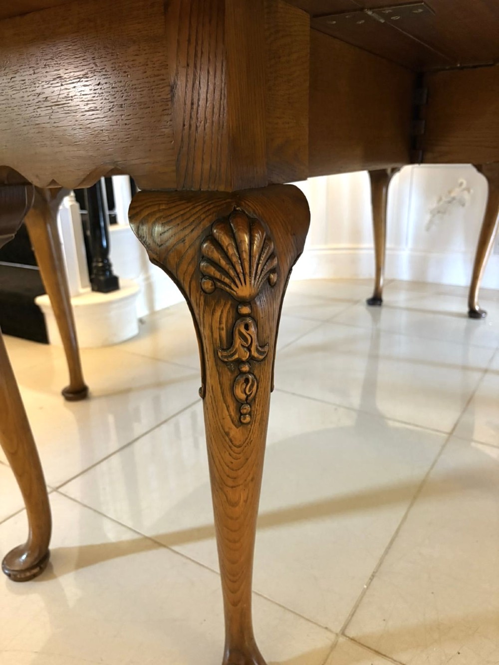 A large oval figured walnut wake dining table featuring drop leaves and cabriole legs ending in pad feet. View VIII