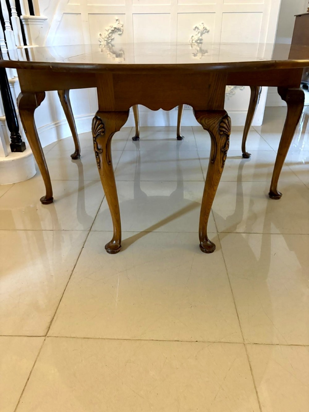 A large oval figured walnut wake dining table featuring drop leaves and cabriole legs ending in pad feet. View IX