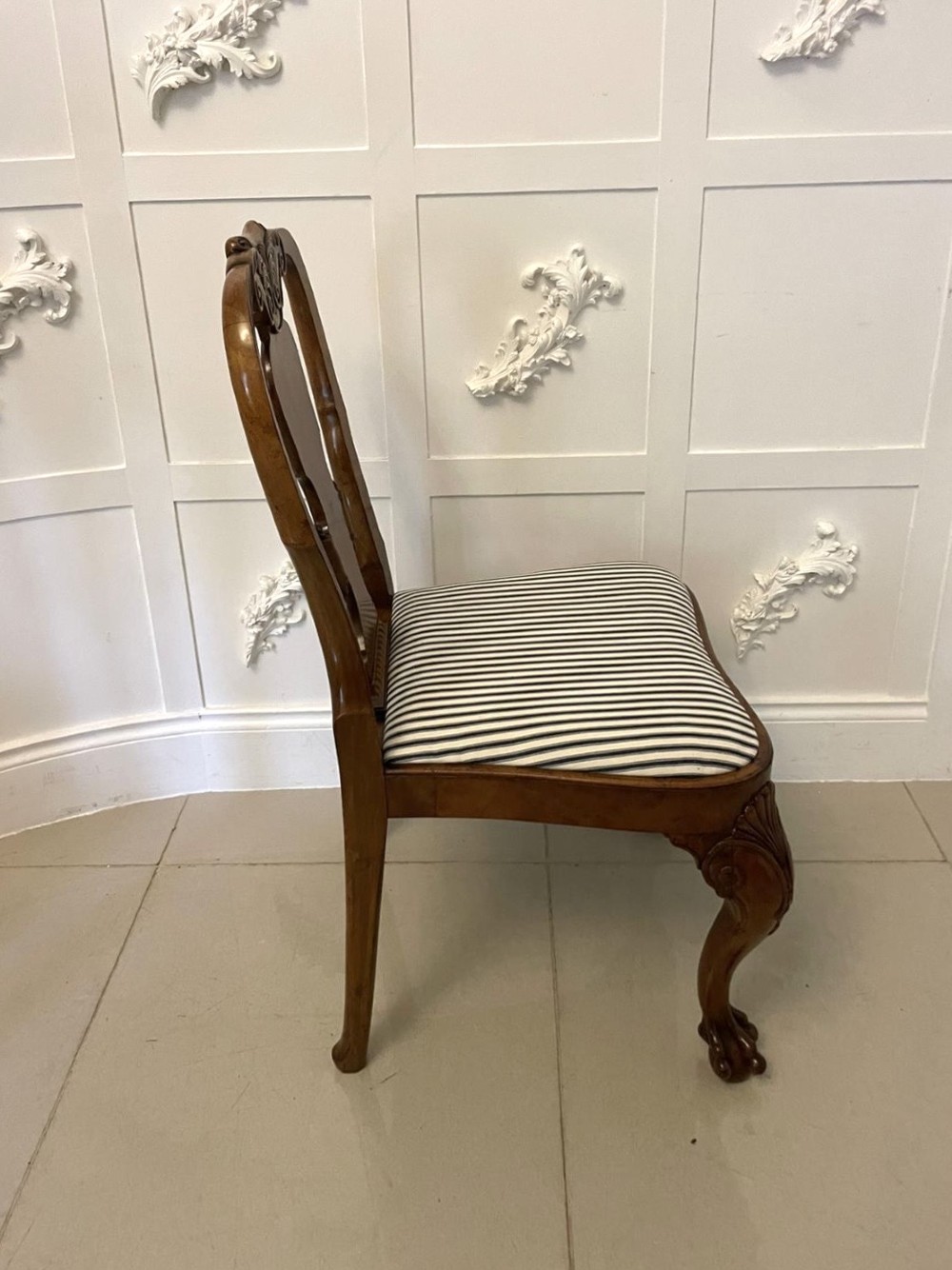 A set of twelve Victorian burr walnut dining chairs with carved splat backs, cabriole legs, and black and white striped upholstered seats. View VII
