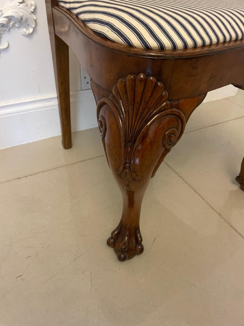A set of twelve Victorian burr walnut dining chairs with carved splat backs, cabriole legs, and black and white striped upholstered seats. View VIII