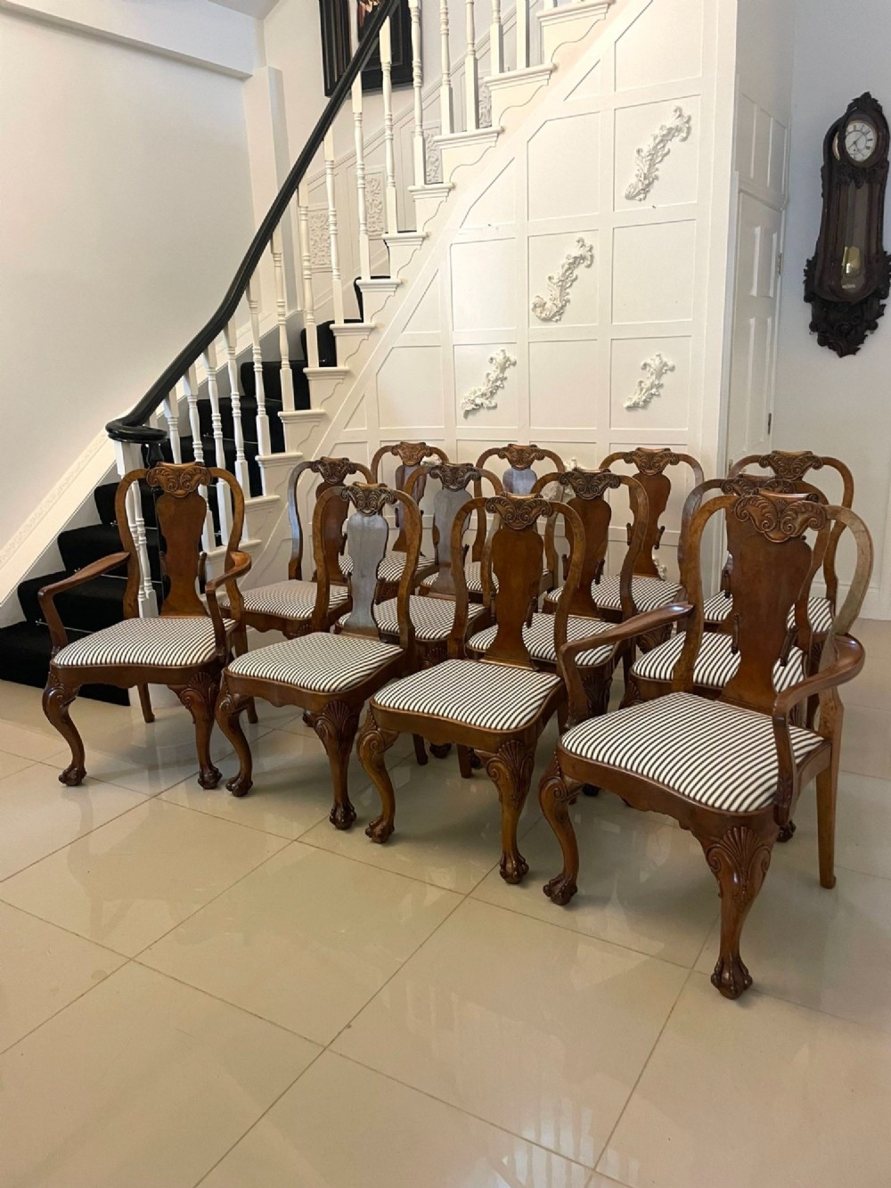 A set of twelve Victorian burr walnut dining chairs with carved splat backs, cabriole legs, and black and white striped upholstered seats. View IX