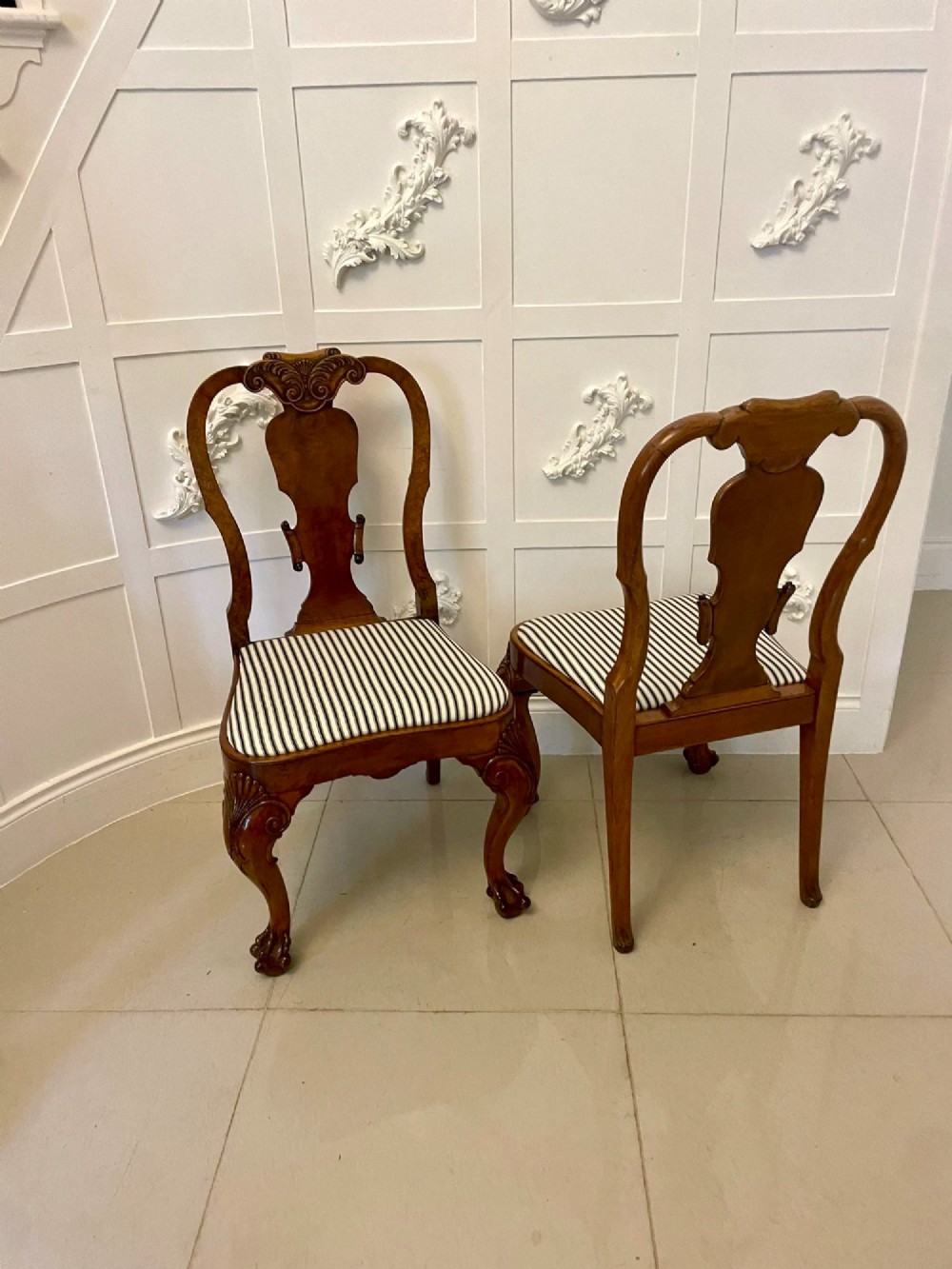 A set of twelve Victorian burr walnut dining chairs with carved splat backs, cabriole legs, and black and white striped upholstered seats. View X