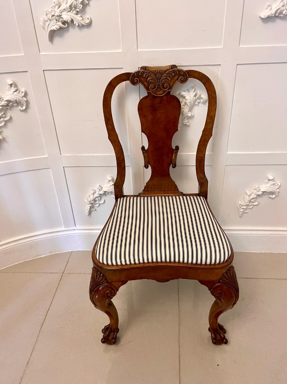 A set of twelve Victorian burr walnut dining chairs with carved splat backs, cabriole legs, and black and white striped upholstered seats. View XI