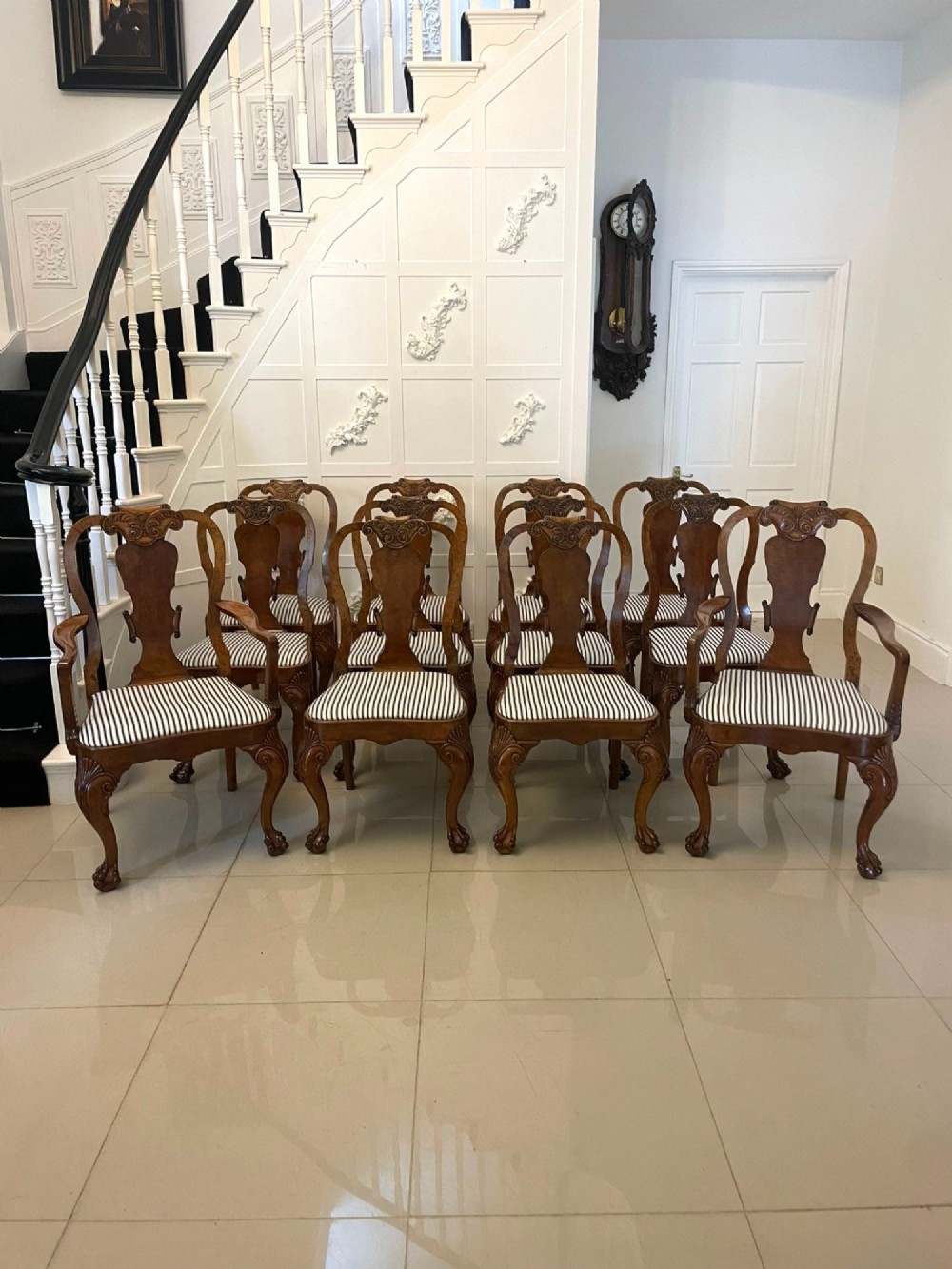 A set of twelve Victorian burr walnut dining chairs with carved splat backs, cabriole legs, and black and white striped upholstered seats. View XIV