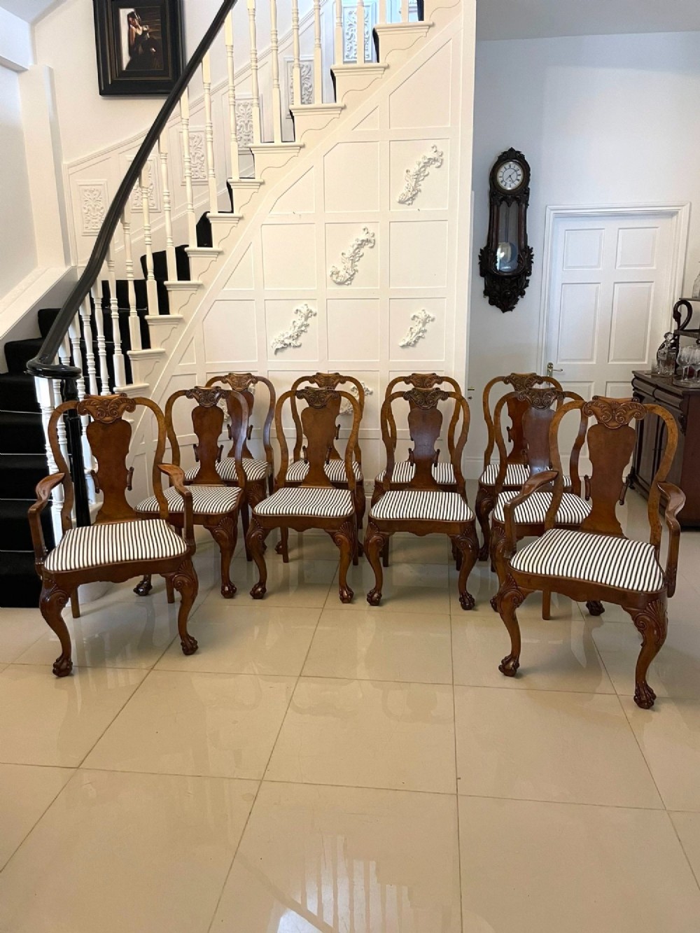 A set of twelve Victorian burr walnut dining chairs with carved splat backs, cabriole legs, and black and white striped upholstered seats. View XV