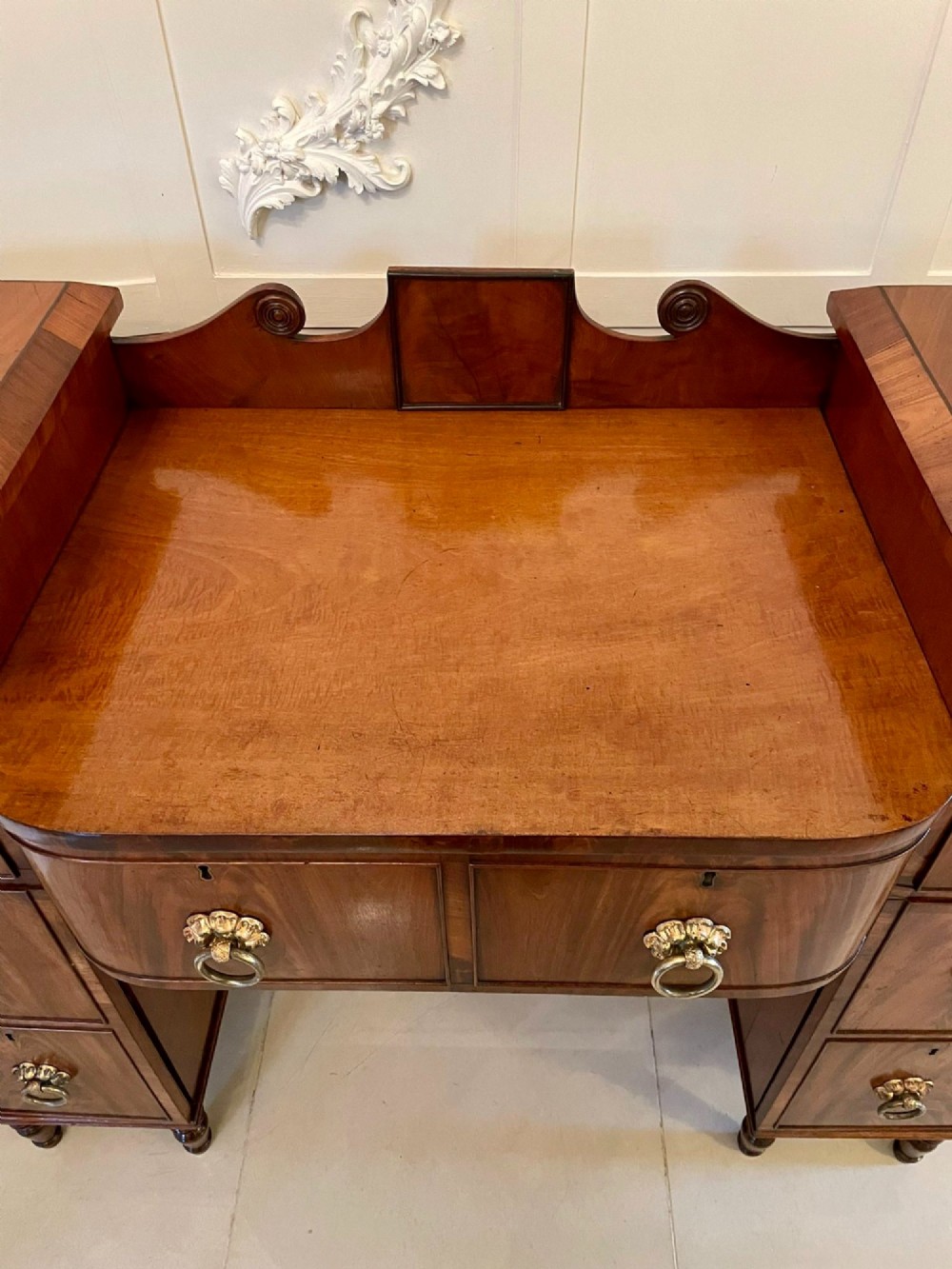 An antique Regency mahogany secretaire sideboard featuring twin pedestals, multiple drawers with brass ring pulls, and a scrolled backboard gallery. View II