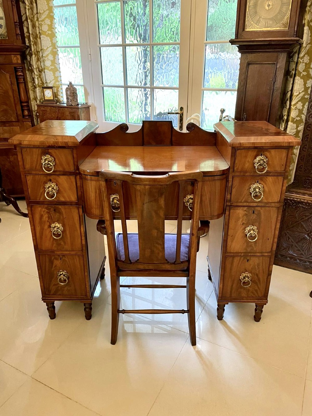 An antique Regency mahogany secretaire sideboard featuring twin pedestals, multiple drawers with brass ring pulls, and a scrolled backboard gallery. View XIV