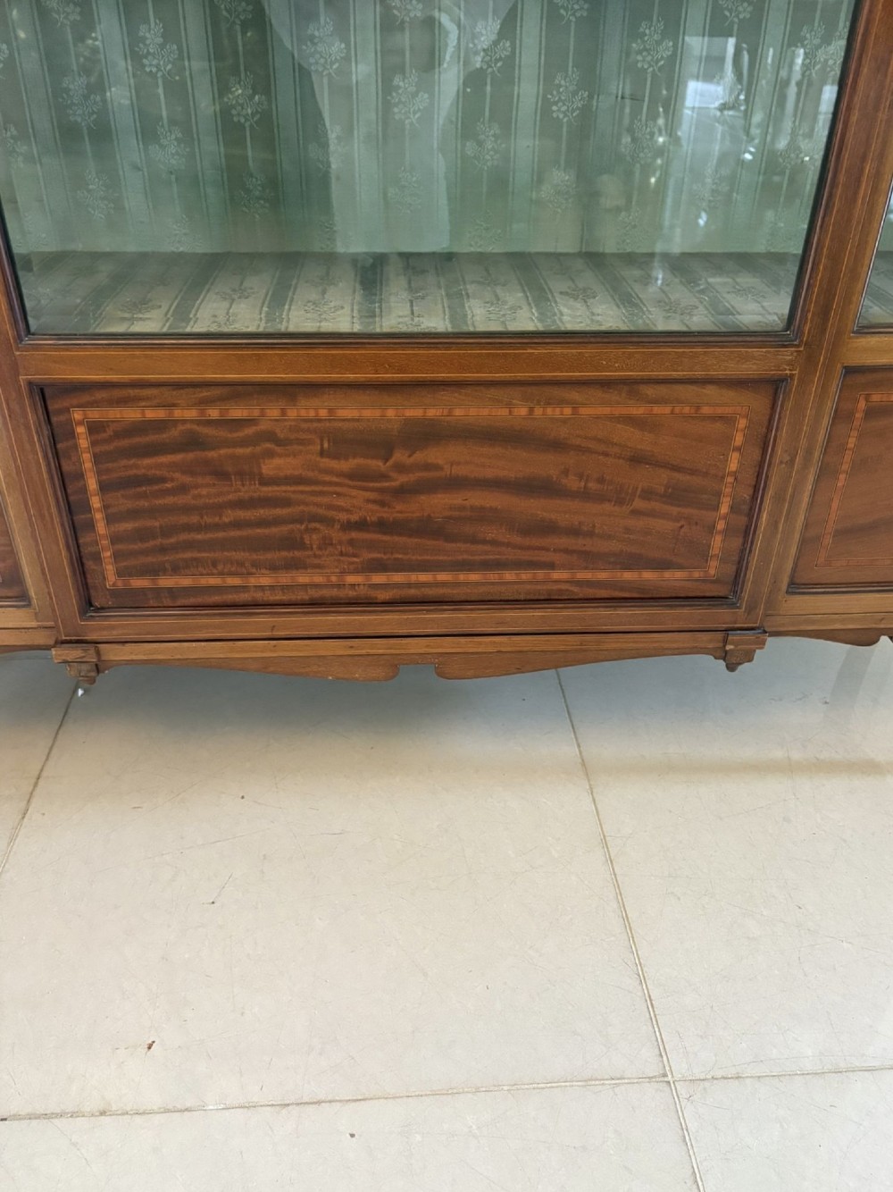 An Edwardian inlaid mahogany display cabinet featuring three glazed doors with decorative glazing bars and a fabric-lined interior. View VIII