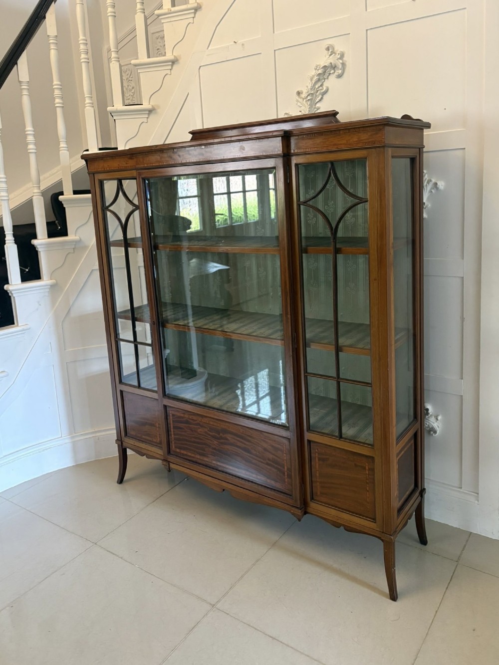 An Edwardian inlaid mahogany display cabinet featuring three glazed doors with decorative glazing bars and a fabric-lined interior. View XII