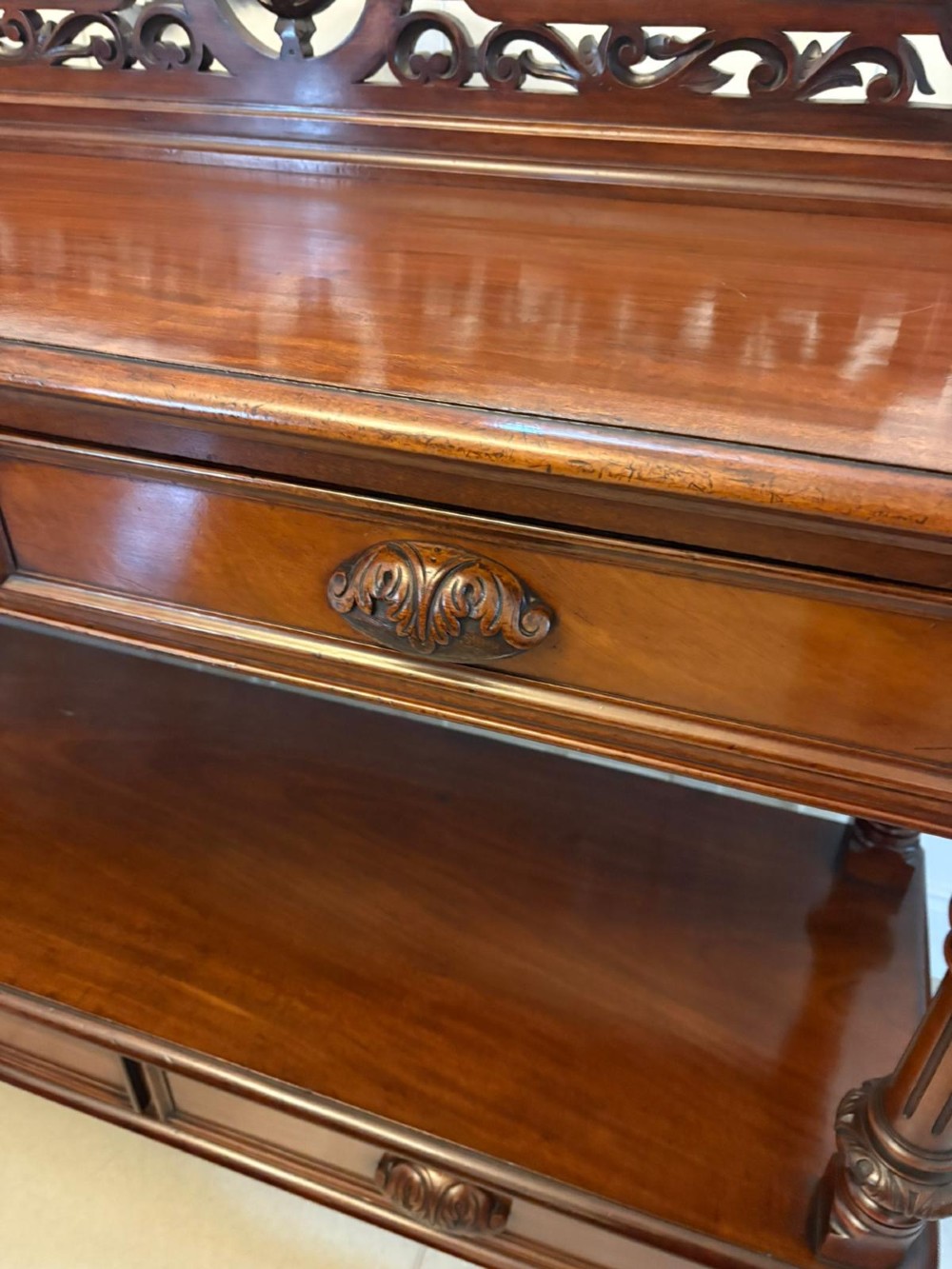 A Victorian mahogany buffet server featuring an openwork carved gallery back, four drawer compartments, turned columns, and an open lower shelf. View XI