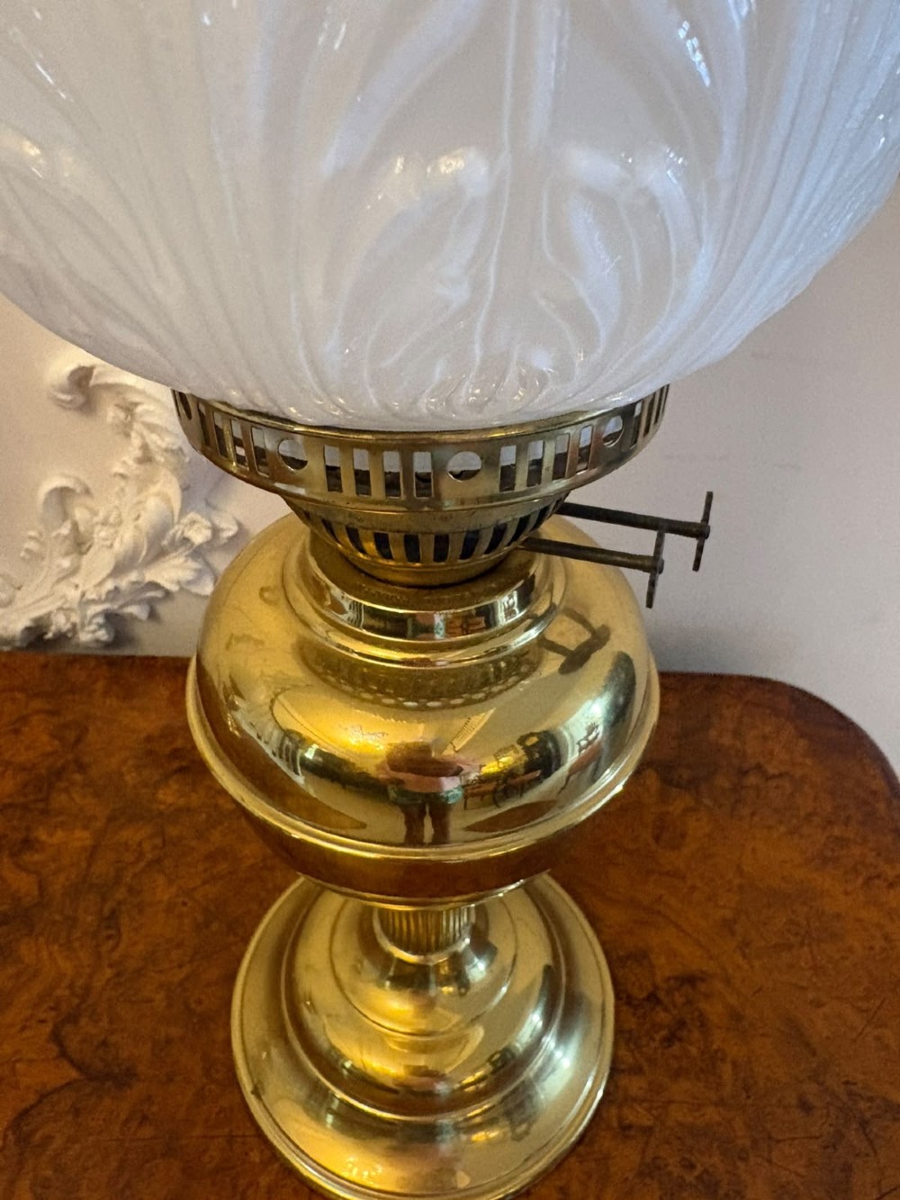 A near pair of Edwardian brass oil lamps featuring moulded white opaline glass shades and clear glass chimneys. View VII