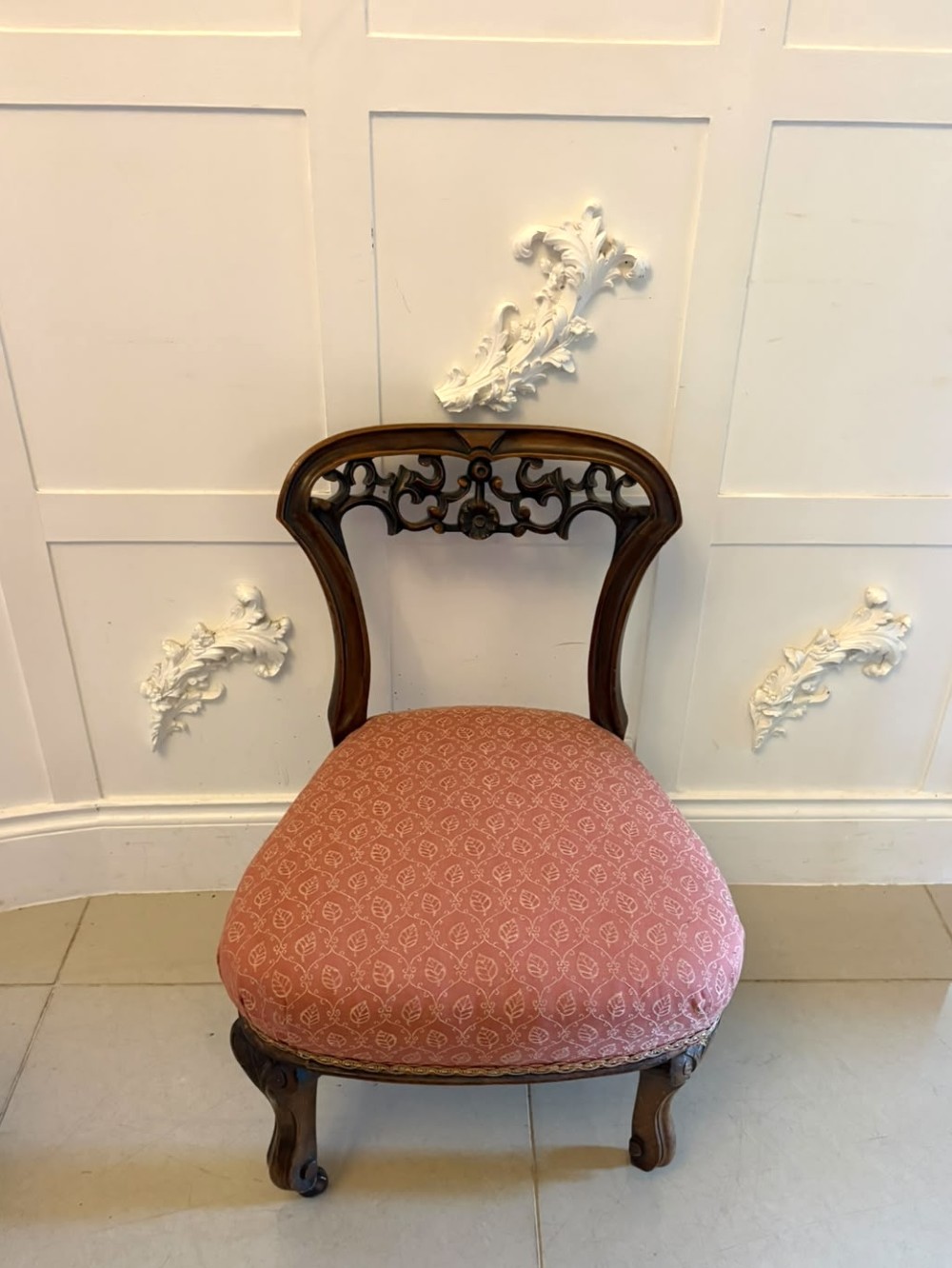 A pair of Victorian carved walnut side chairs with openwork backs and terracotta patterned fabric seats. View VIII
