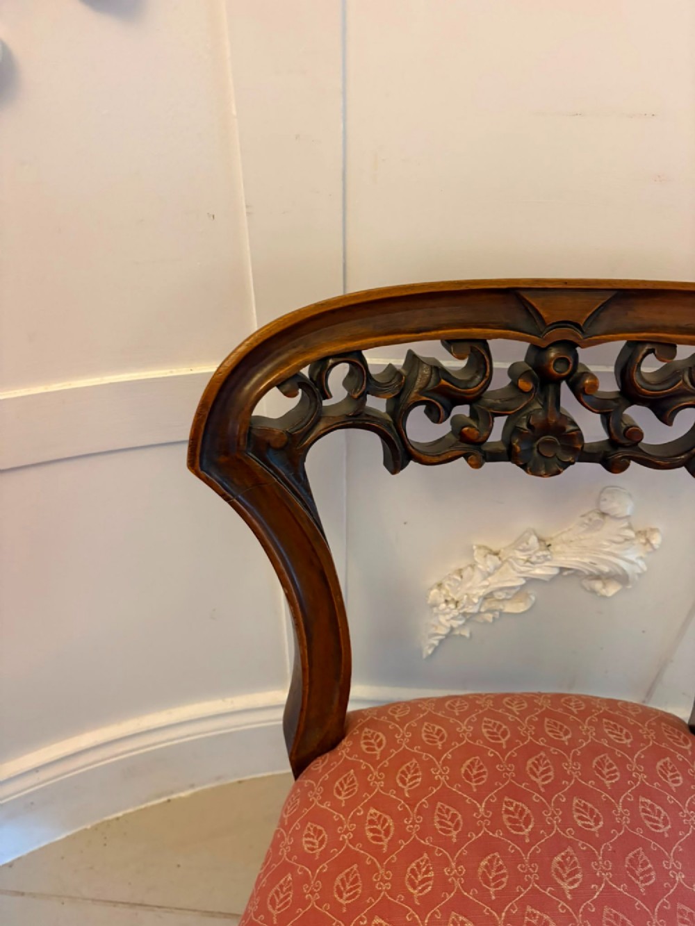 A pair of Victorian carved walnut side chairs with openwork backs and terracotta patterned fabric seats. View X