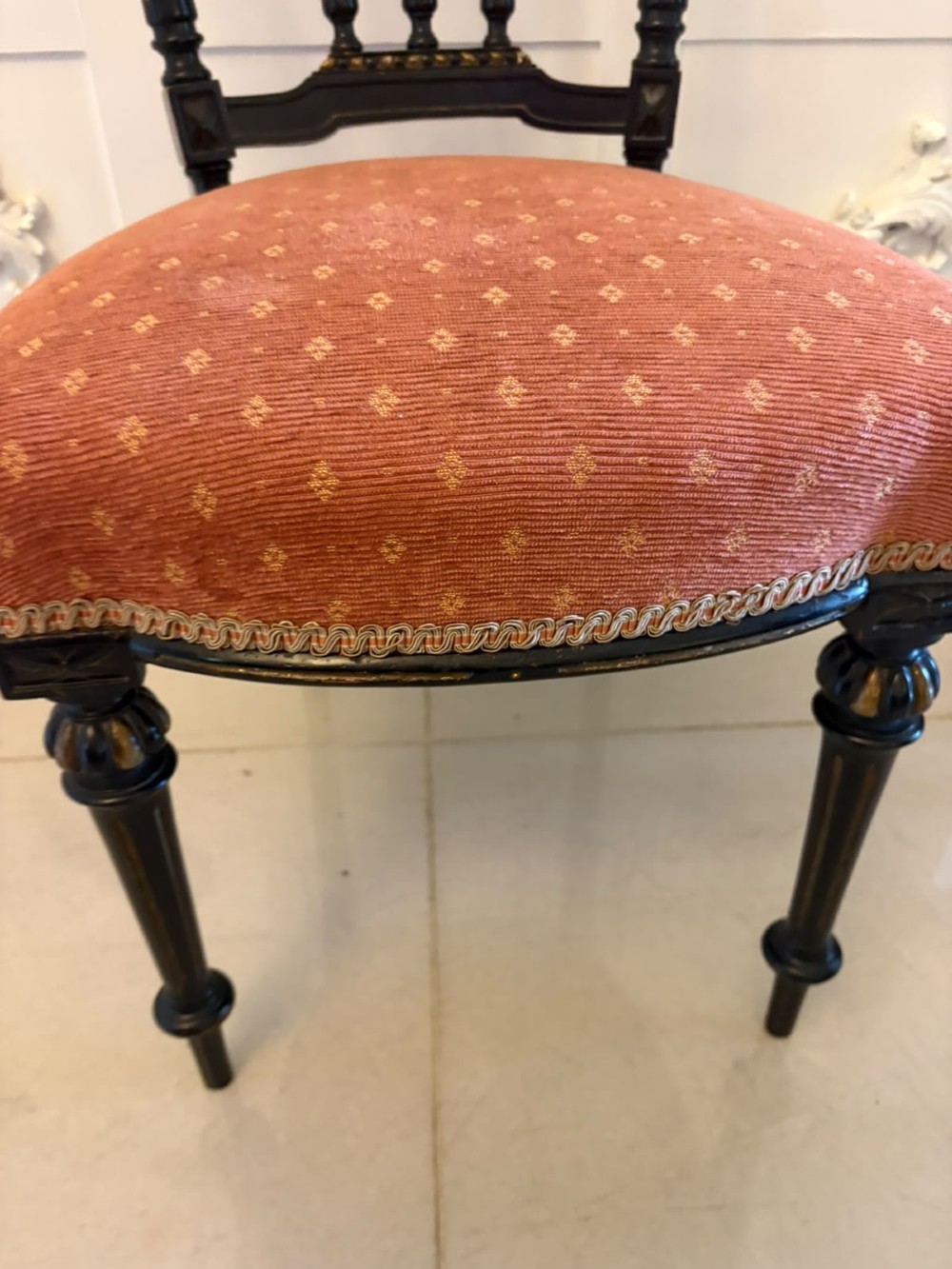 A set of four antique Victorian side chairs featuring ebonised black frames with turned spindle backrests, gilt details, turned front legs, and terracotta patterned upholstered seats. View IV