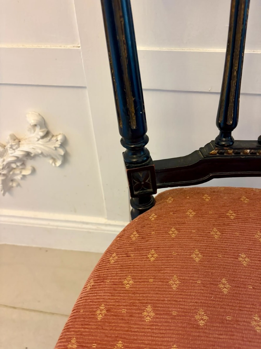 A set of four antique Victorian side chairs featuring ebonised black frames with turned spindle backrests, gilt details, turned front legs, and terracotta patterned upholstered seats. View VII