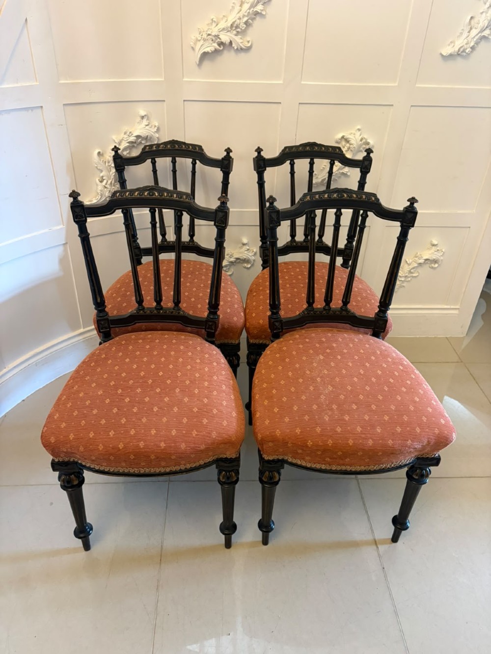 A set of four antique Victorian side chairs featuring ebonised black frames with turned spindle backrests, gilt details, turned front legs, and terracotta patterned upholstered seats. View XV