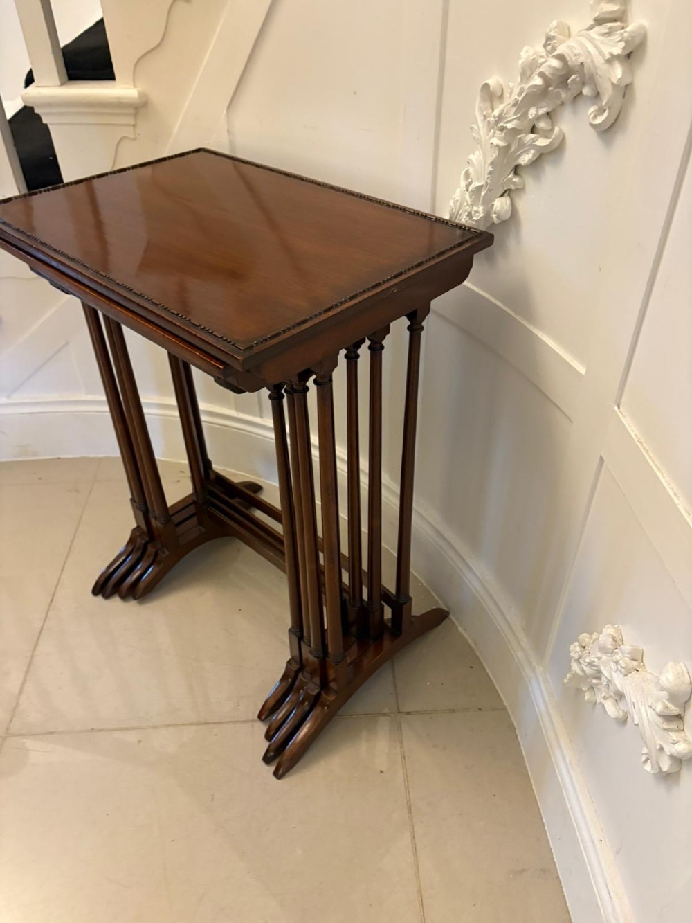 A set of four graduated Edwardian mahogany tables standing stepped outwards to display their inlaid boxwood borders and turned supports. View II