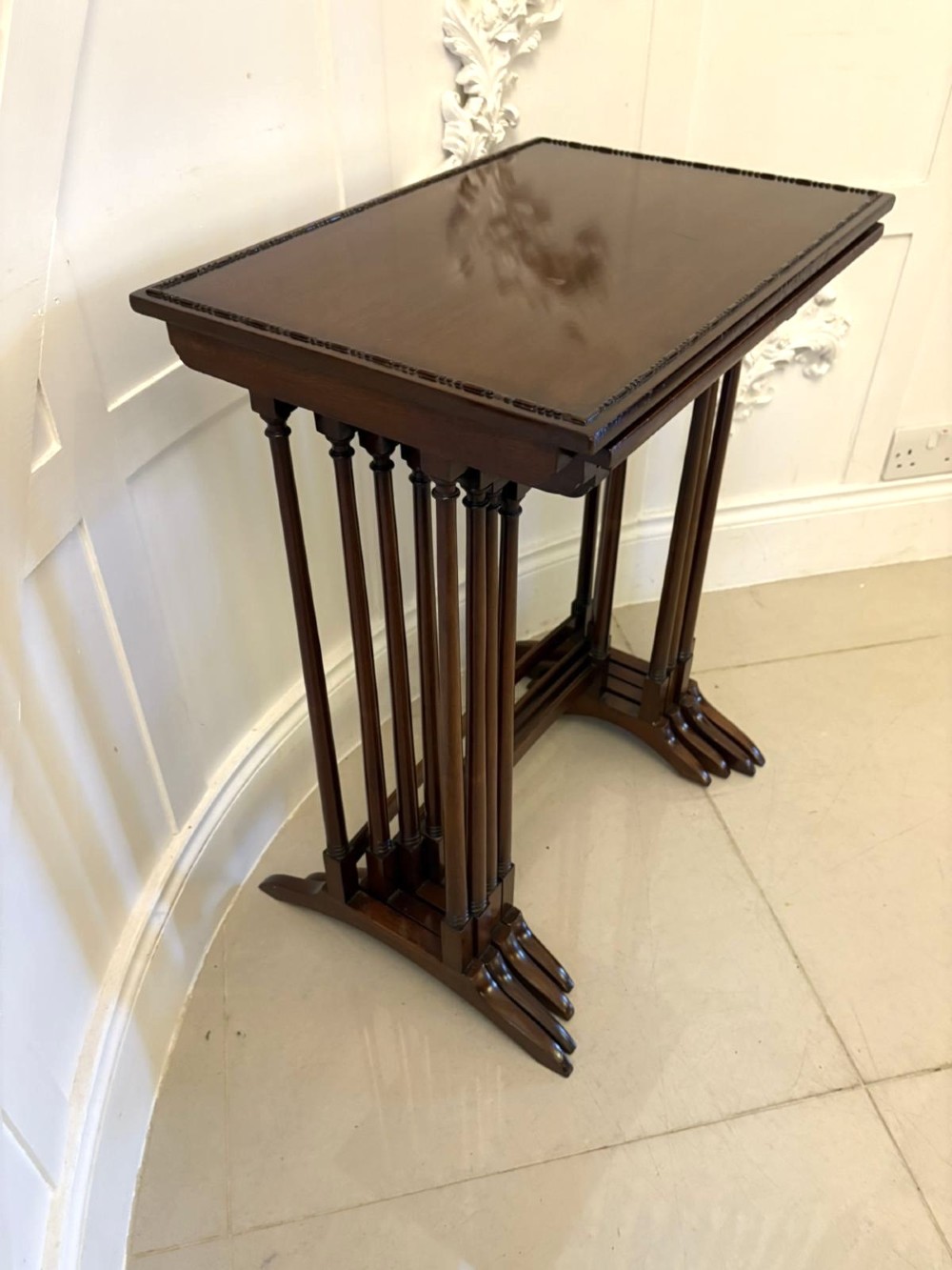 A set of four graduated Edwardian mahogany tables standing stepped outwards to display their inlaid boxwood borders and turned supports. View III