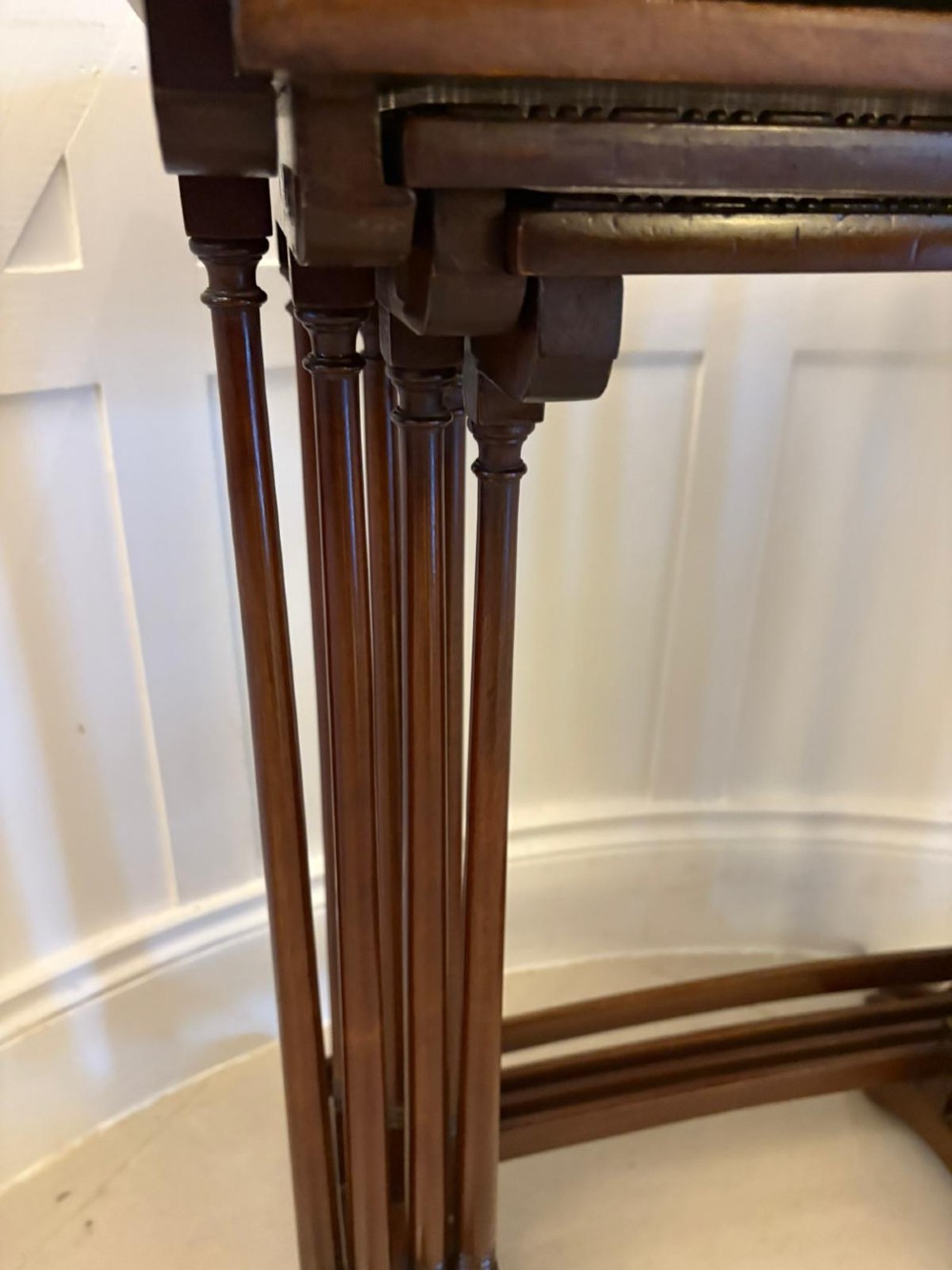 A set of four graduated Edwardian mahogany tables standing stepped outwards to display their inlaid boxwood borders and turned supports. View IV