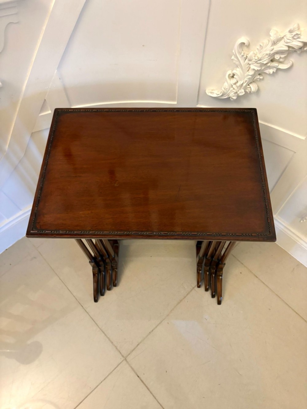 A set of four graduated Edwardian mahogany tables standing stepped outwards to display their inlaid boxwood borders and turned supports. View X