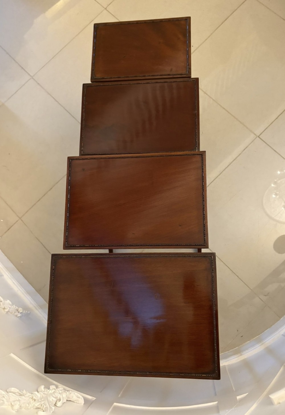 A set of four graduated Edwardian mahogany tables standing stepped outwards to display their inlaid boxwood borders and turned supports. View XI