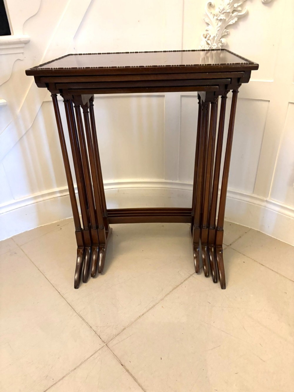 A set of four graduated Edwardian mahogany tables standing stepped outwards to display their inlaid boxwood borders and turned supports. View XIV