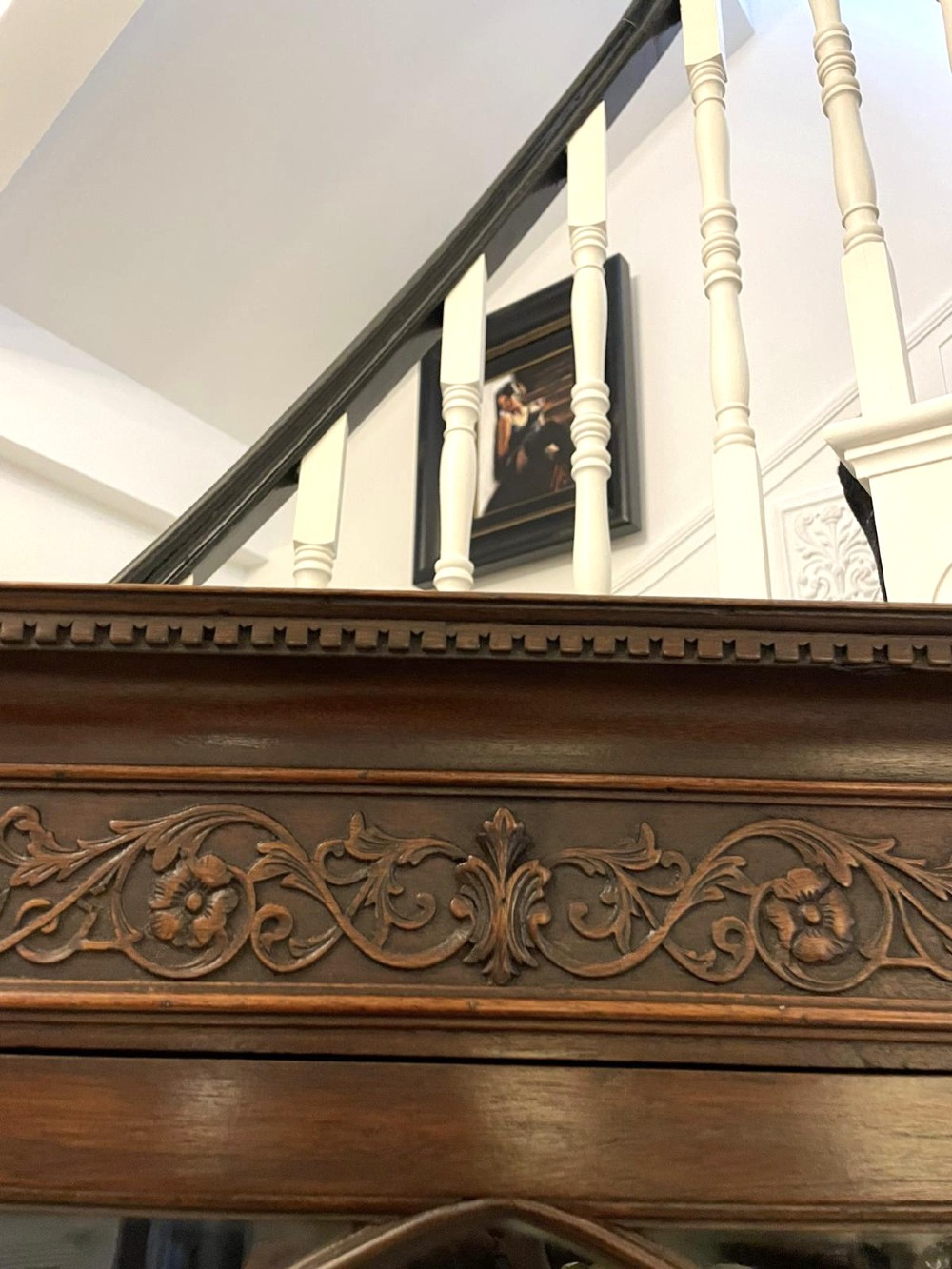 A tall mahogany corner cabinet with two astragal glazed doors featuring curved oval tracery and a carved foliate frieze. View XI