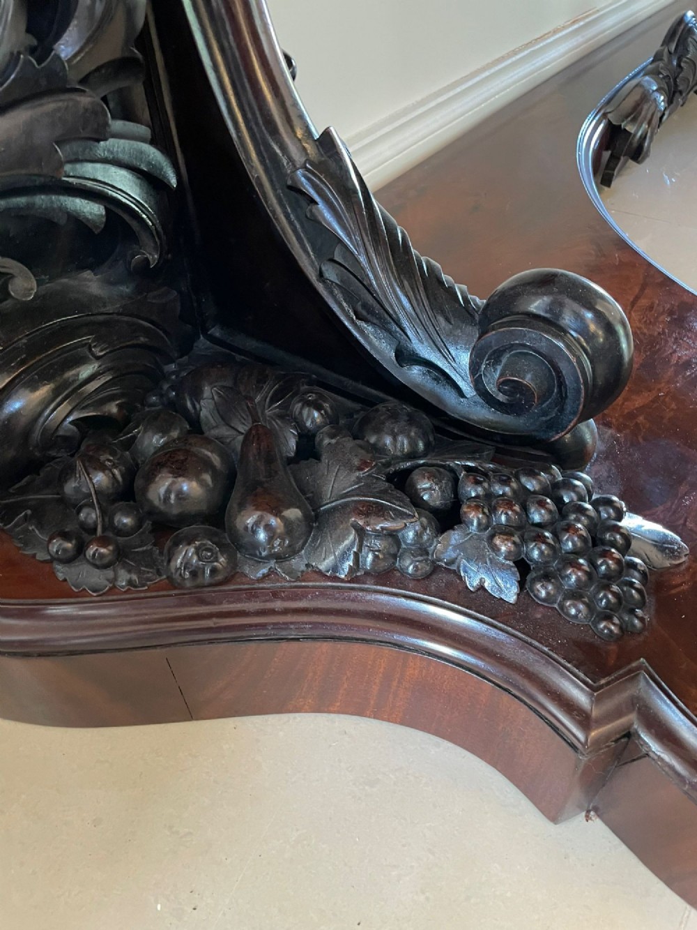 An exceptionally large Victorian dark mahogany console table featuring carved caryatid figures, elaborate scrollwork, a large arched mirror back, and a contoured plinth base. View IV