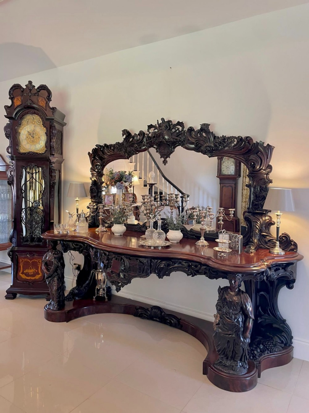 An exceptionally large Victorian dark mahogany console table featuring carved caryatid figures, elaborate scrollwork, a large arched mirror back, and a contoured plinth base. View XI
