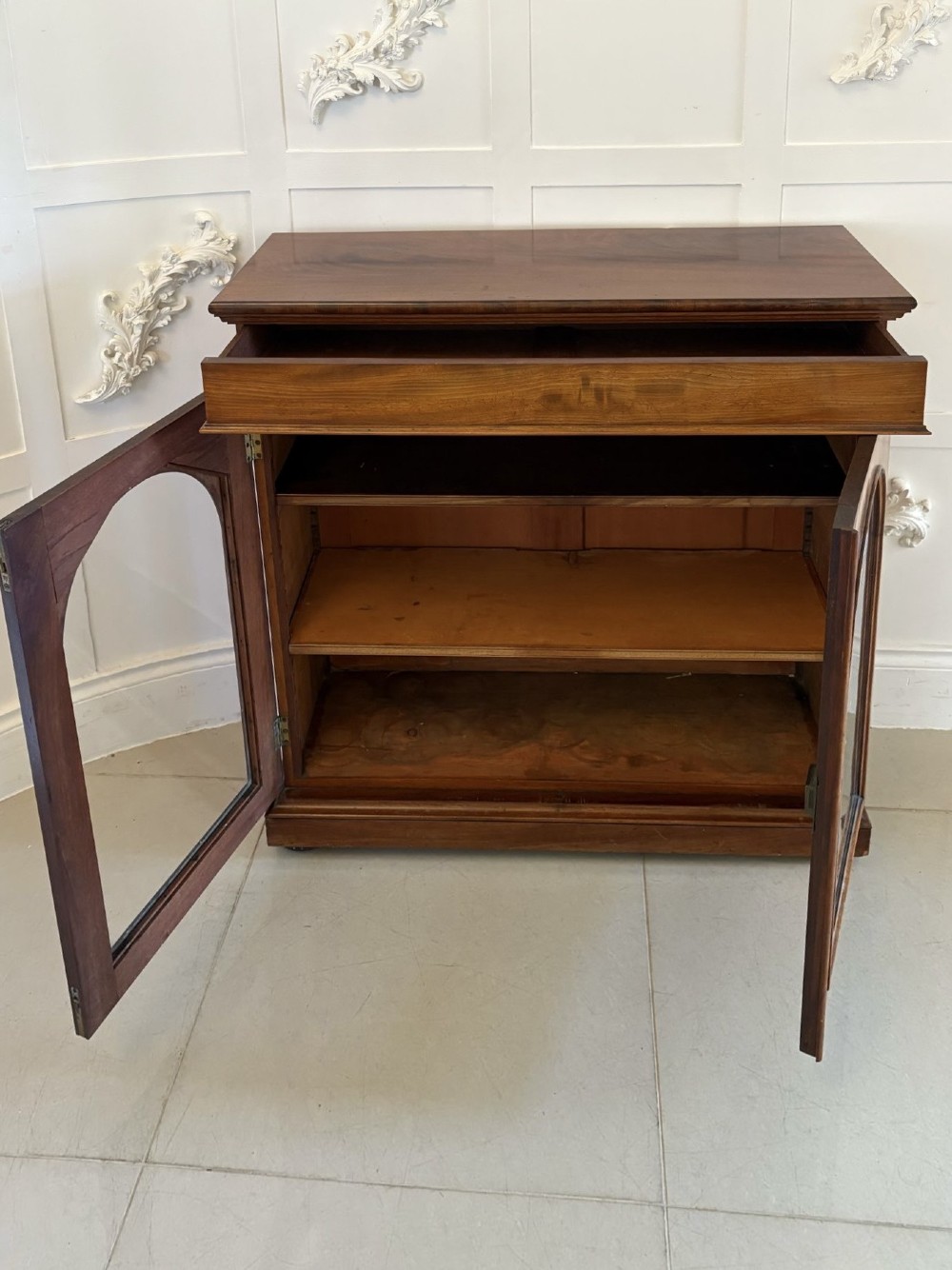 A low Victorian mahogany bookcase featuring two arched glazed doors revealing interior shelving above a plinth base. View III