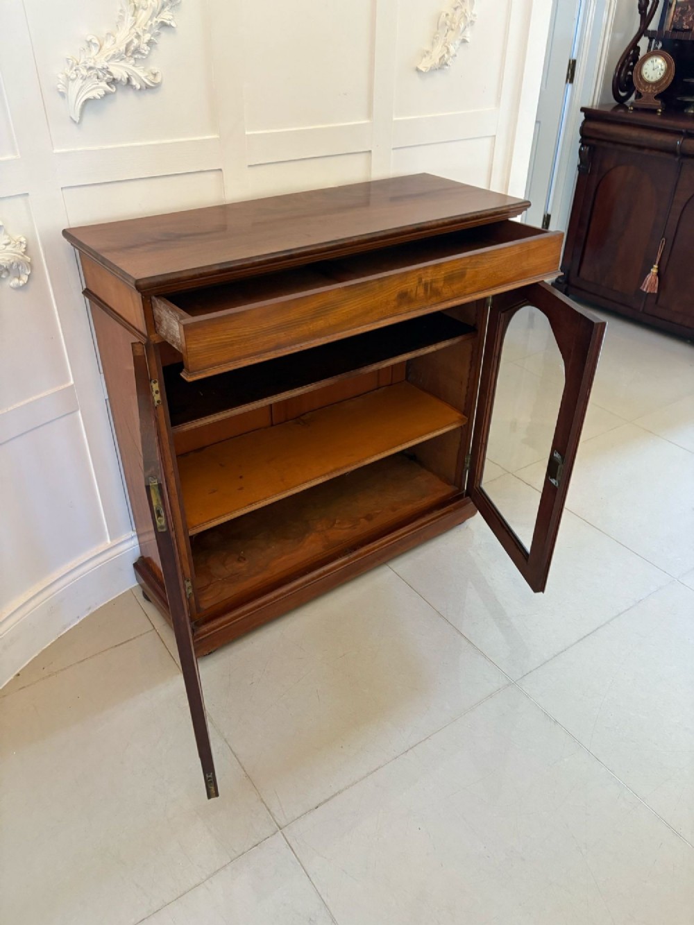 A low Victorian mahogany bookcase featuring two arched glazed doors revealing interior shelving above a plinth base. View IV