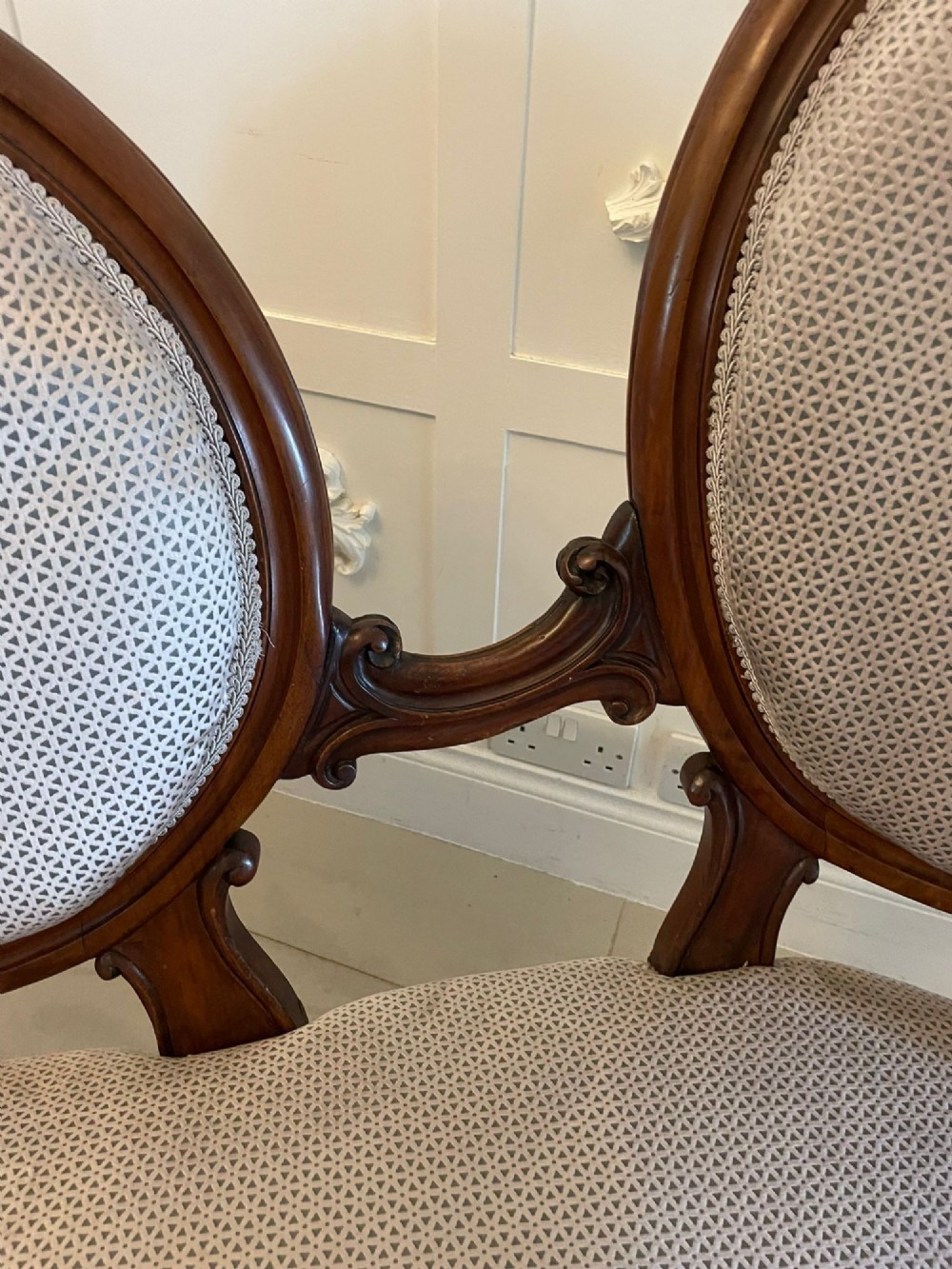 A Victorian carved walnut cameo back sofa featuring three oval upholstered panels, floral crestings, and cabriole legs on castors. View XI