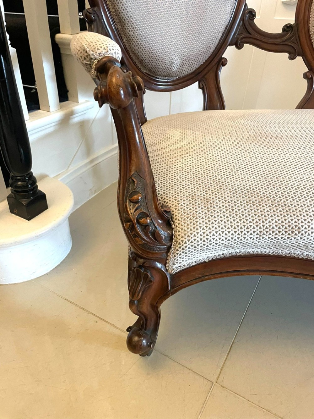 A Victorian carved walnut cameo back sofa featuring three oval upholstered panels, floral crestings, and cabriole legs on castors. View XII